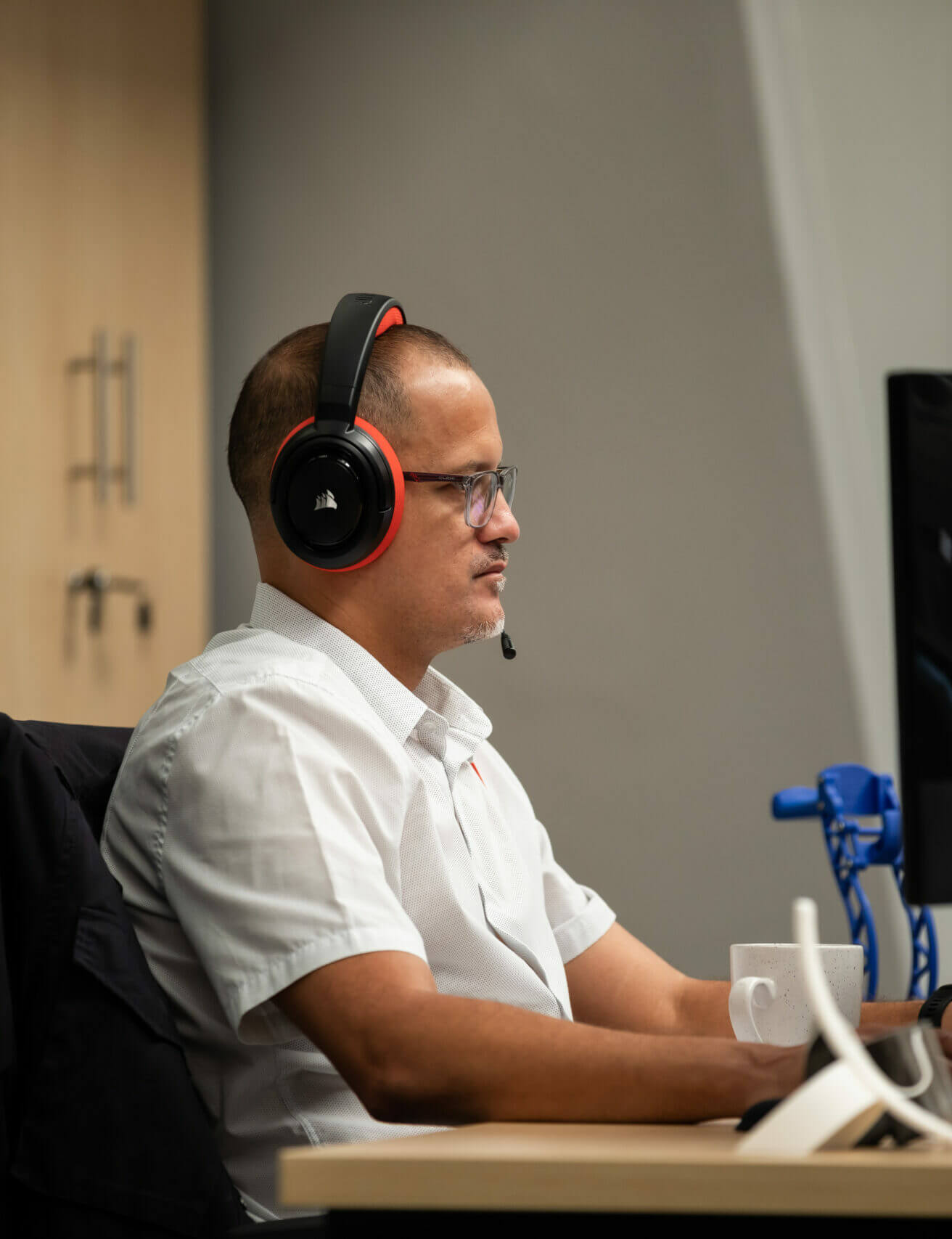 headshot of Haefele software developer with headset on at computer